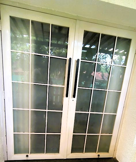 Elegant French window style balcony door with black metal frame.